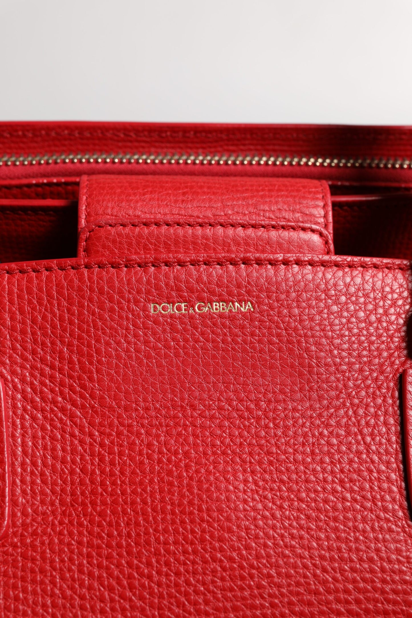 Bolso de mano con asa superior y placa con el logotipo en piel de becerro roja