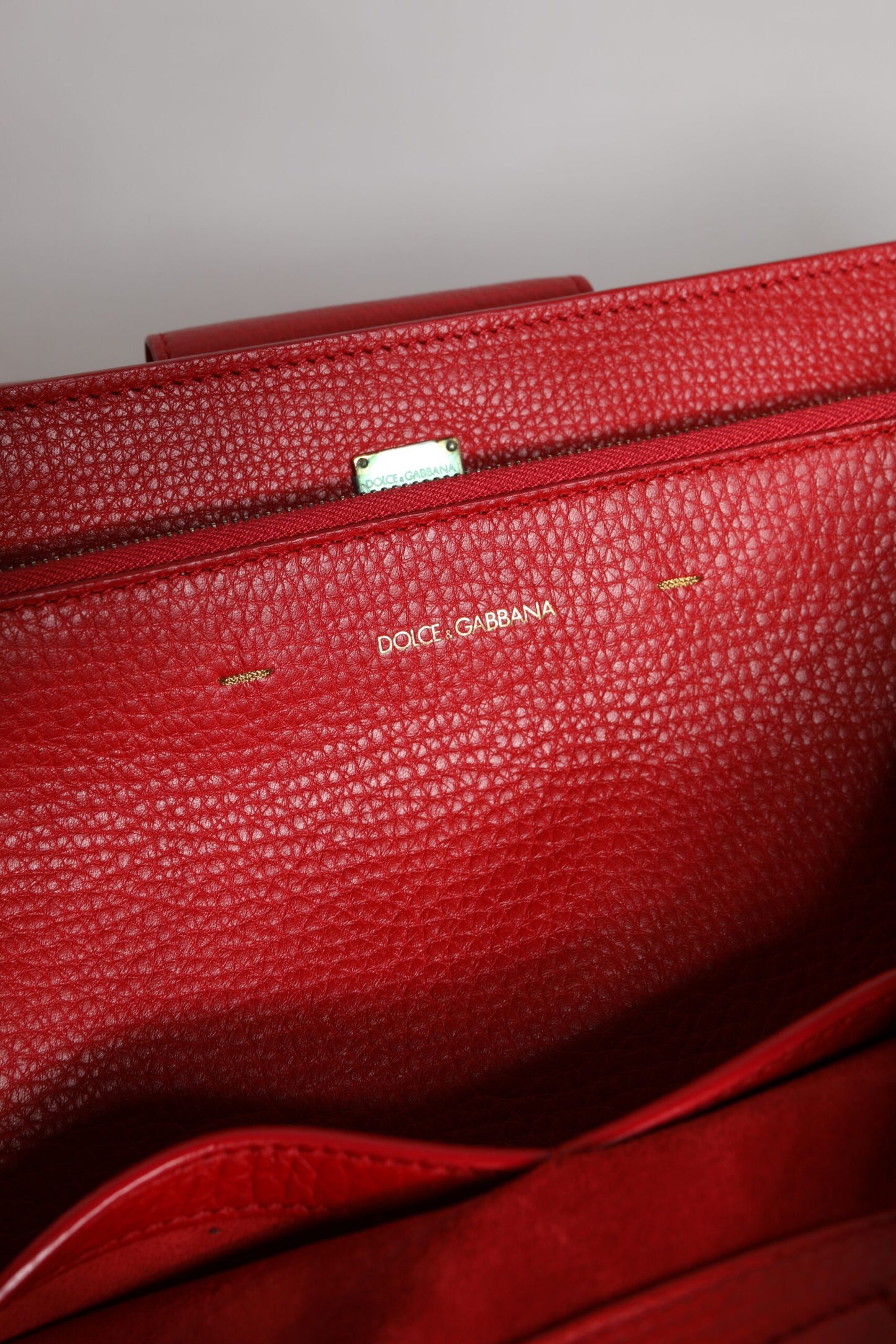 Bolso de mano con asa superior y placa con el logotipo en piel de becerro roja