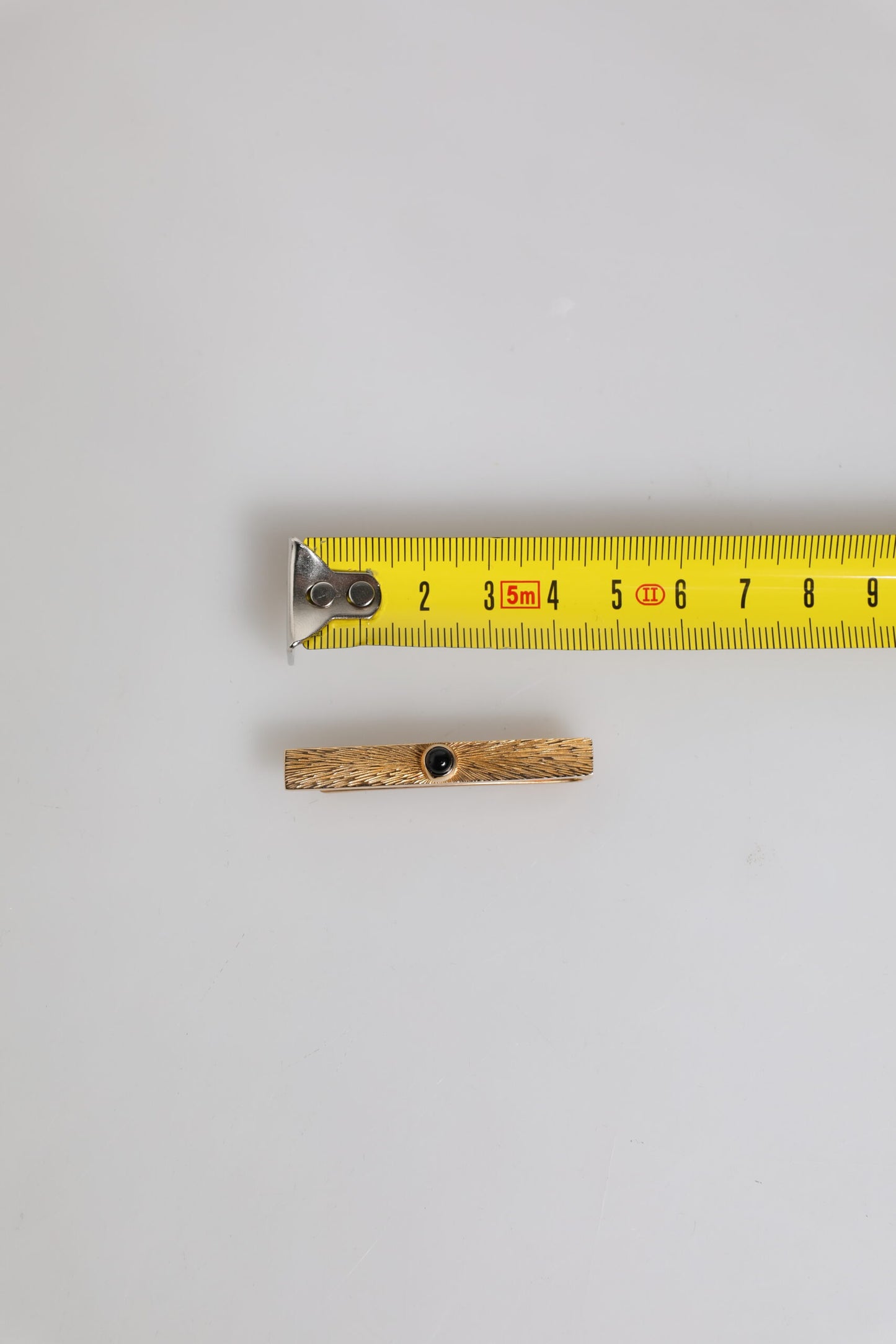 Pince à cravate en laiton doré et saphir noir