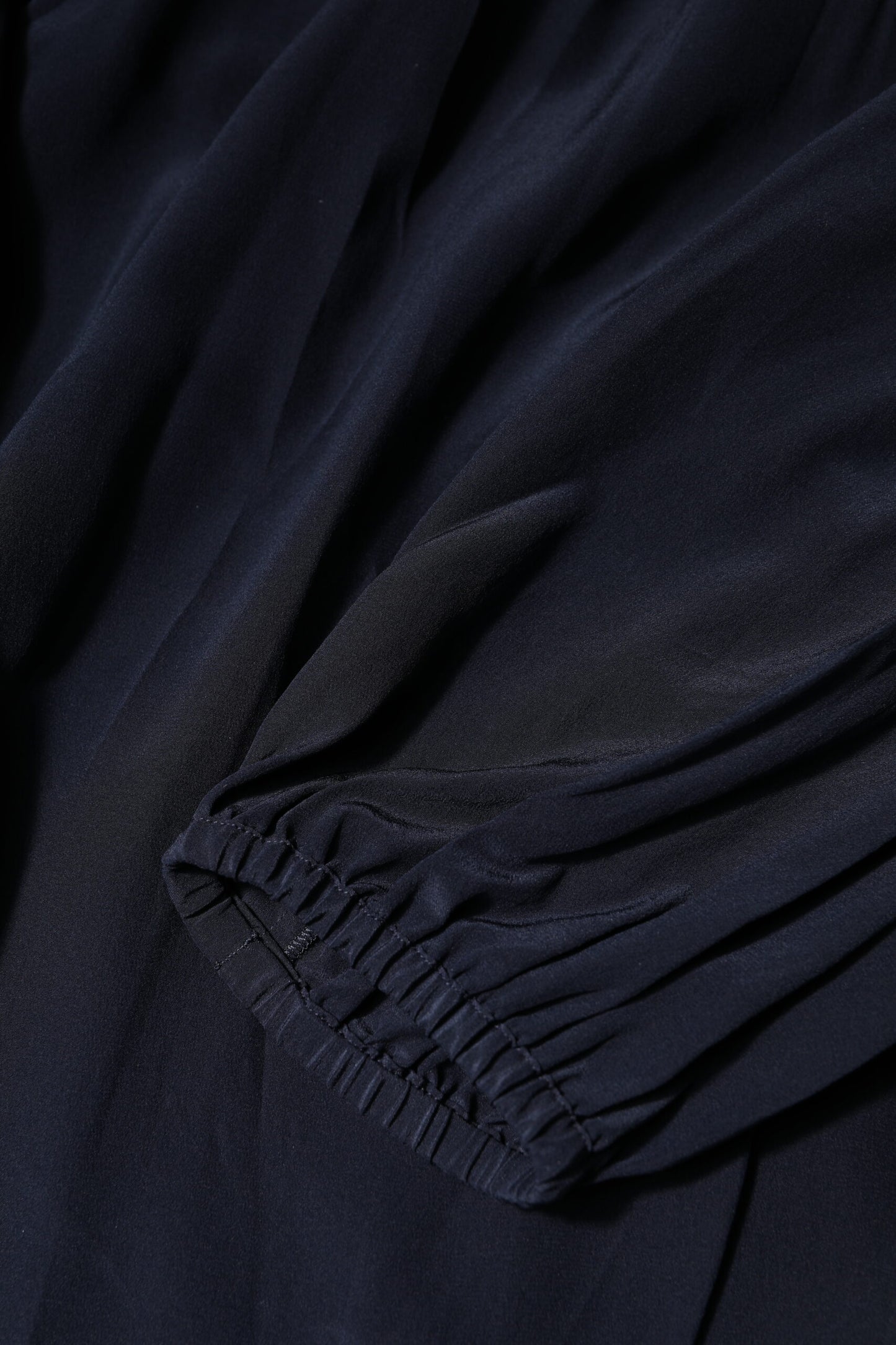 Blusa de seda azul con cuello alto y mangas largas