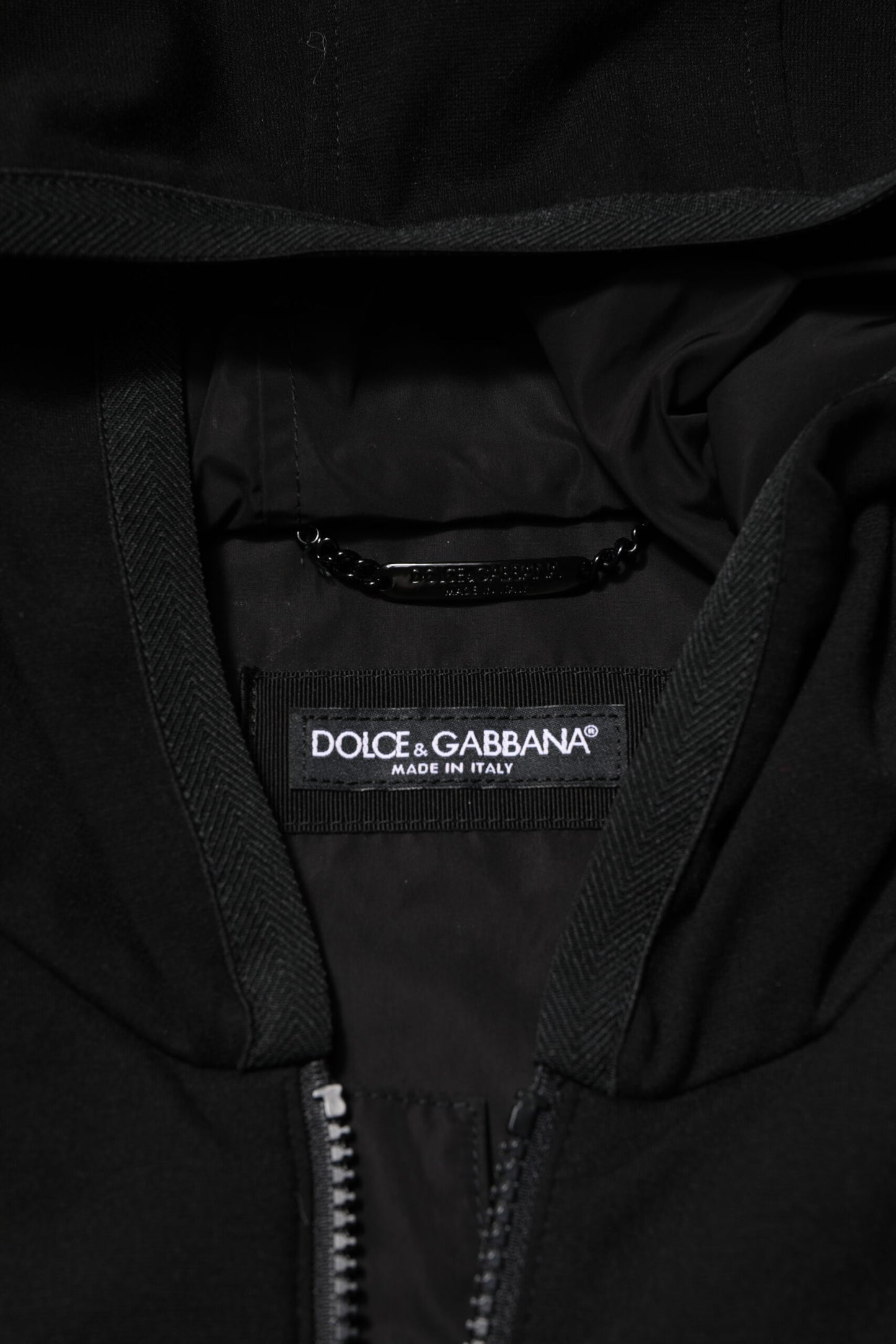 Chaqueta negra sin mangas con capucha y placa con el logotipo