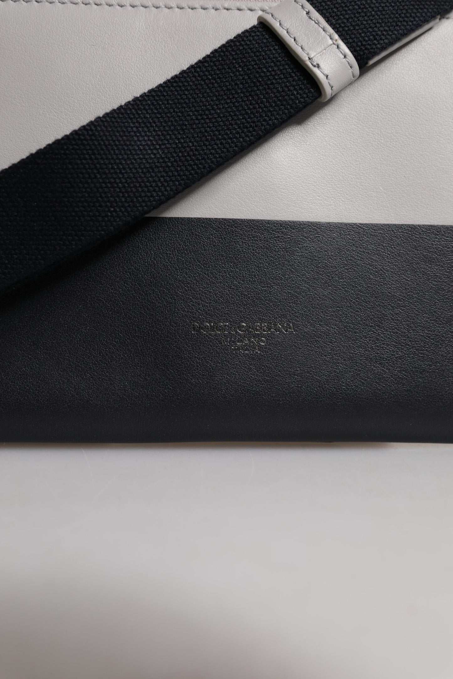 Bolso bandolera de piel blanca y negra con logo grabado