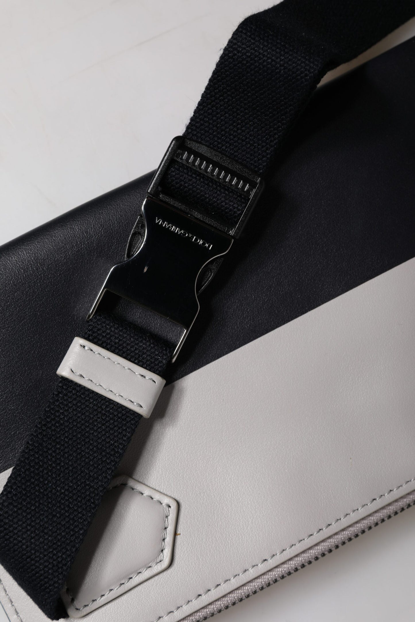 Bolso bandolera de piel blanca y negra con logo grabado