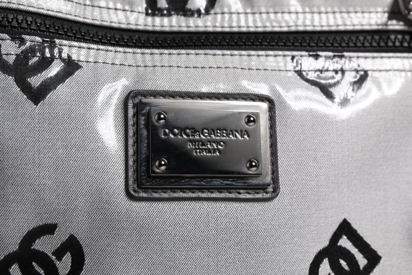 Mochila de poliéster gris y negra con placa del logotipo de DG