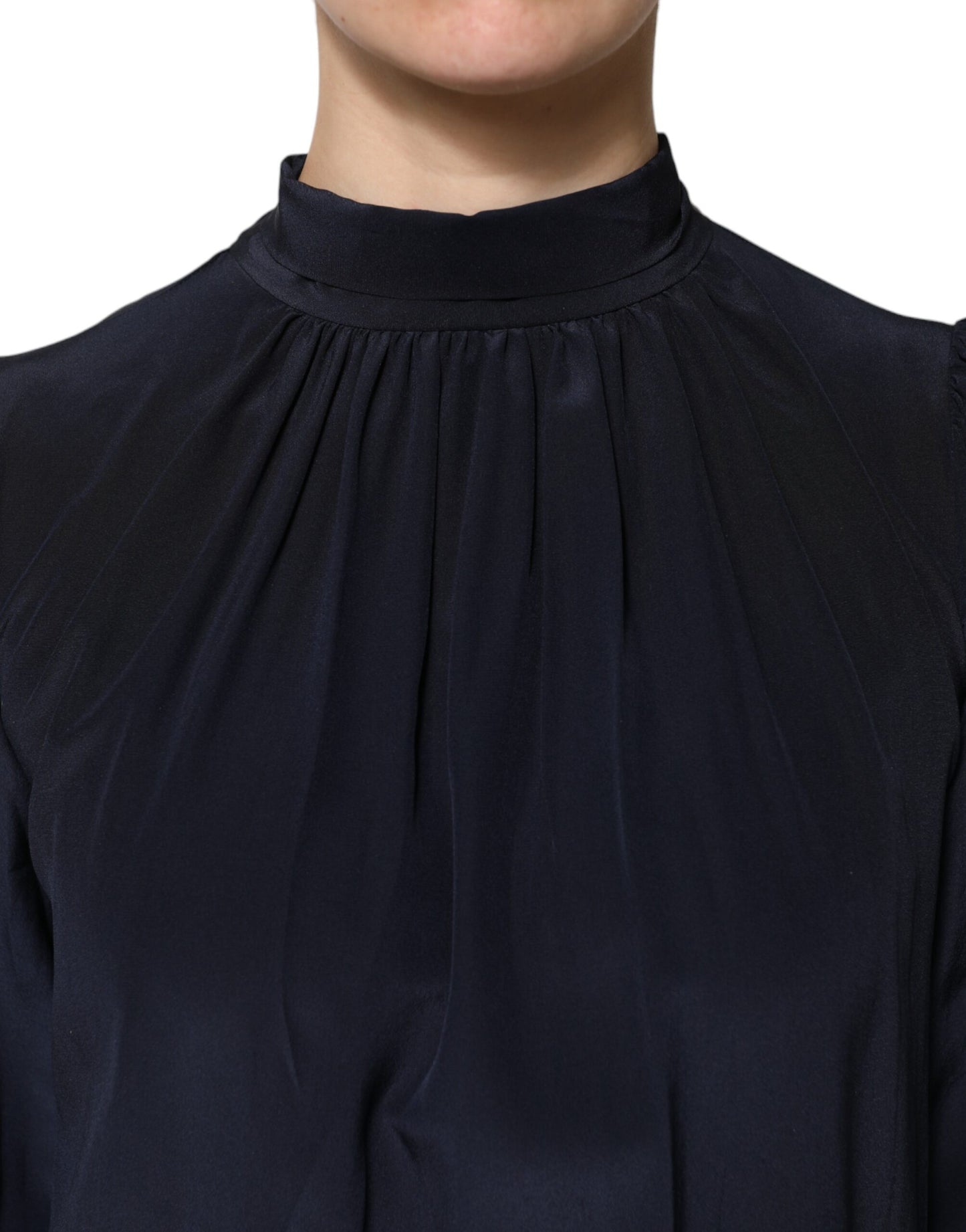 Blusa de seda azul con cuello alto y mangas largas
