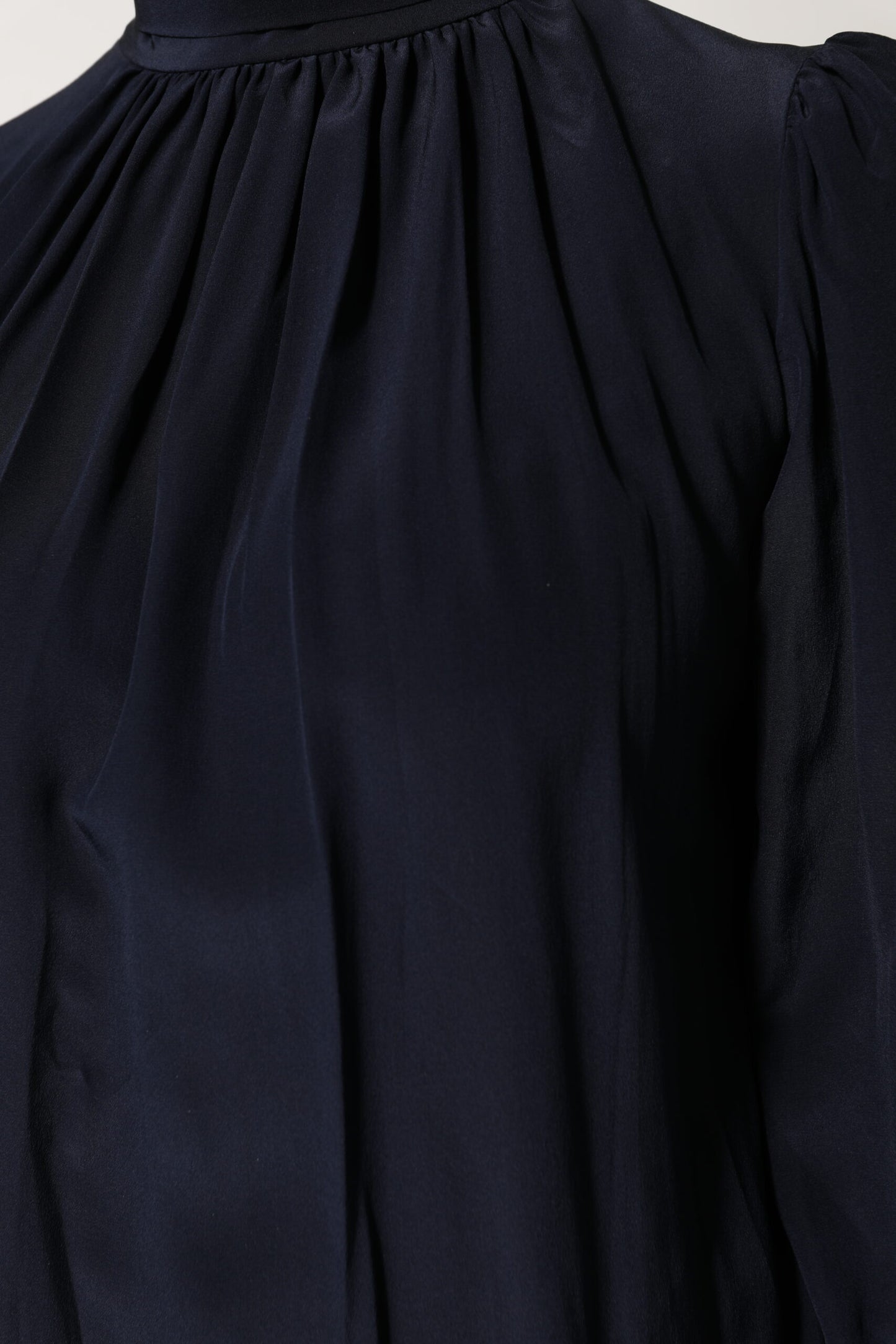 Blusa de seda azul con cuello alto y mangas largas