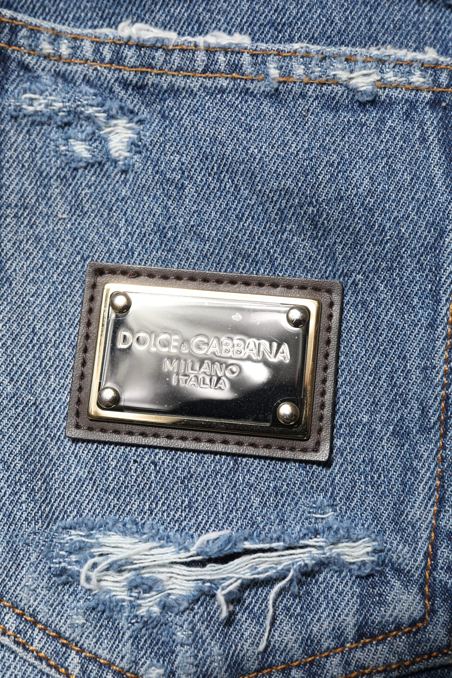 Vaqueros de mezclilla de algodón azul desgastado con placa de logotipo
